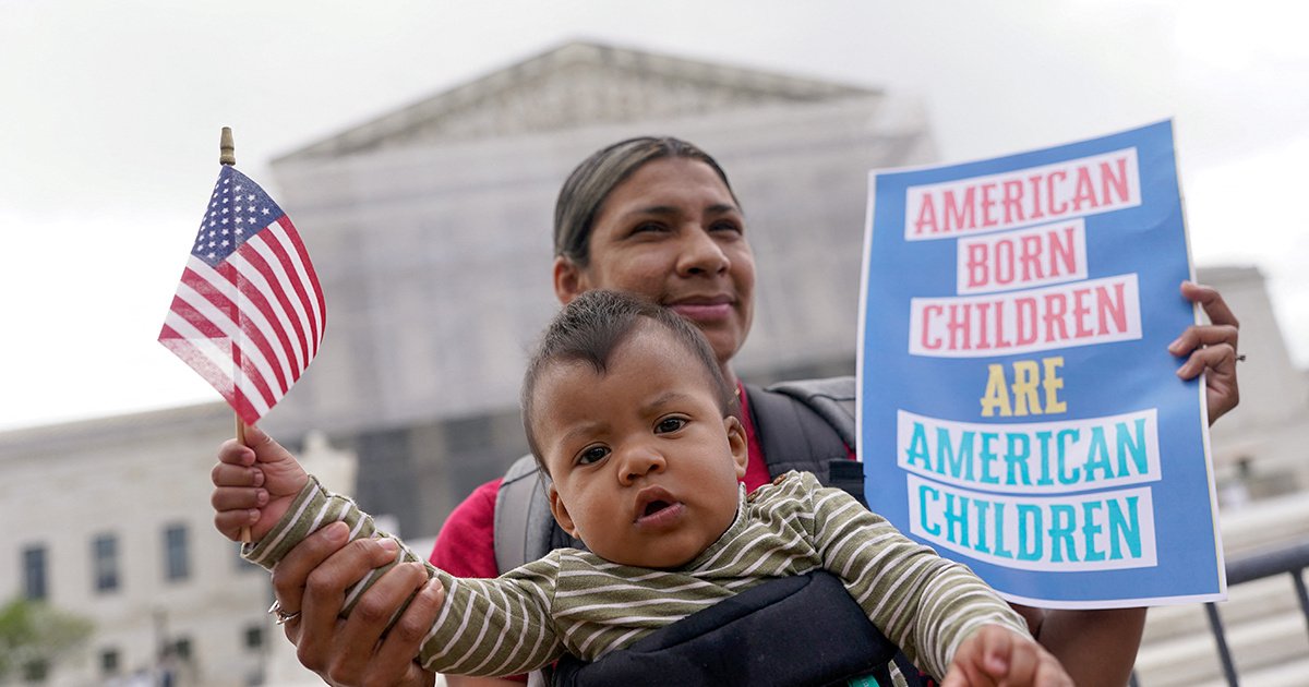 A parent and child holding an American flag outside the U.S. Supreme Court